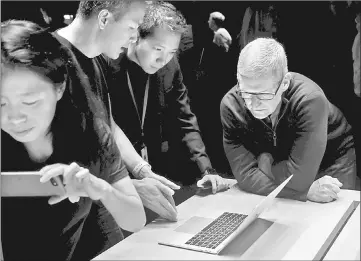  ??  ?? Apple CEO Tim Cook (right) views the new MacBook Pro in the demo room after an Apple media event in Cupertino, California in October. — Reuters photo