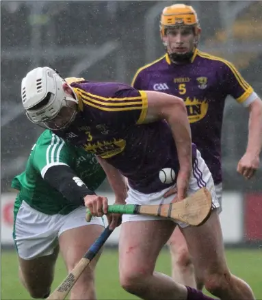  ??  ?? Full-back Liam Ryan has support from Simon Donohoe as the rain comes pouring down.