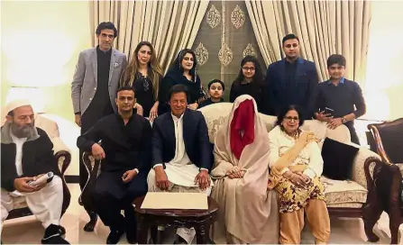  ?? — AFP ?? Family affair: Khan (seated, third from left) posing for a group photo with Wattoo (in red veil) and their family members following the solemnisat­ion ceremony in Lahore.