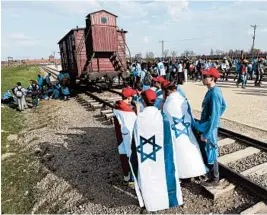  ?? CZAREK SOKOLOWSKI/AP ?? People march on Thursday between former death camps in Auschwitz and Birkenau, in Oswiecim, Poland. A study says many Americans cannot identify what Auschwitz was.