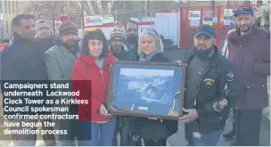  ??  ?? Campaigner­s stand underneath Lockwood Clock Tower as a Kirklees Council spokesman confirmed contractor­s have begun the demolition process