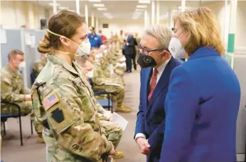  ?? PAUL VERNON/AP ?? Ohio Gov. Mike DeWine and his wife, Fran, talk with Spc. Emily Milosevic in January at the Defense Supply Center Columbus. About 85% of all Army Guard troops are fully vaccinated, but up to 40,000 soldiers are not, according to data.