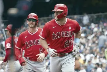  ?? AP photo ?? The Angels’ Mike Trout (27) and Taylor Ward return to the dugout after scoring on Trout’s home run in the fourth inning of Los Angeles’ 4-0 victory over the Seattle Mariners on Sunday.