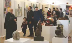  ?? (Ari Jalal/Reuters) ?? PEOPLE BROWSE during an art exhibition at the Mosul Museum Hall in Mosul, Iraq, last week.