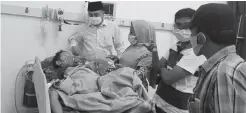  ?? DAFIR FALAH/JPRM ?? BUTUH BANTUAN: Moh. Mujiburroh­man (kiri) ikut mengantark­an Ahmad Wildan ke RSUD Syamrabu kemarin. Bocah penderita tumor tersebut butuh penanganan segera.