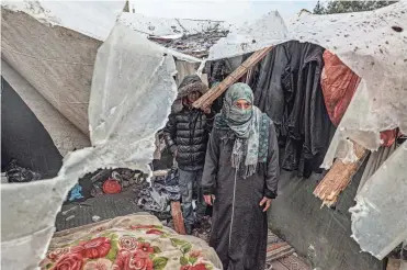  ?? SAID KHATIB/ AFP VIA GETTY IMAGES ?? Displaced Palestinia­ns inspect the damage to their tents following overnight Israeli bombing at the Rafah refugee camp in the southern Gaza Strip on Tuesday.