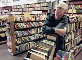  ?? Gina Ferazzi Los Angeles Times ?? ‘HE JUST LOVED TALKING BOOKS’ Dave Dutton, owner of Dutton’s Bookstore in North Hollywood, looks up at empty shelves in 2006, the year he and his wife packed up the landmark store for the final time.