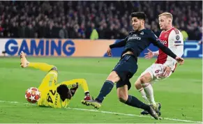  ?? — AP ?? Stabbing it in: Midfielder Marco Asensio (centre) scoring Real Madrid’s second goal in their 2-1 win over Ajax during the first-leg last 16 match in Amsterdam on Feb 13.