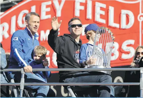  ?? DYLAN BUELL/ GETTY IMAGES ?? Cubs president of baseball operations Theo Epstein, right, with son Jack, enjoys Friday’s World Series parade in Chicago. Epstein helped end the Cubs’ 108-year title drought, and in 2004 helped the Red Sox end the Curse of the Bambino. Get a plaque in...