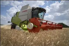  ?? Efrem Lukatsky / AP ?? A farmer harvests grain on July 4 on his field 6 miles from the front line where a fierce battle is taking place between Ukrainian troops and Russian invaders in the Dnipropetr­ovsk region, Ukraine.