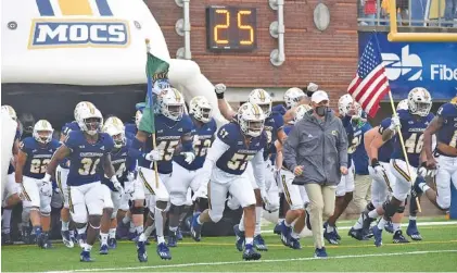  ?? STAFF PHOTO BY MATT HAMILTON ?? The UTC football team takes the field for its game against Mercer on March 27 at Finley Stadium. The Mocs lost 35-28 that Saturday to fall to 3-2 overall and 3-1 in the SoCon, and two days later UTC announced its 2020-21 season was over due to numerous players opting out. Still ahead this year for UTC is a full schedule that kicks off in early September.