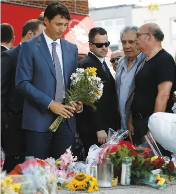  ?? PHOTO AFP ?? Le premier ministre Justin Trudeau est allé déposer des fleurs en la mémoire des victimes de la fusillade de Toronto, hier, à la fontaine de la place Alexander the Great.
