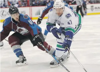  ??  ?? The Canucks’ Sven Baertschi fights for control of the puck with Colorado Avalanche defenceman Cody Goloubef during the second period on Wednesday. Baertschi scored two goals in the victory, including the game-winner.