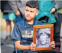  ?? Photo / Paul Taylor ?? Recaro Kouta, 14, with a portrait of his koro PTE Frank Kouta at the Takapau Anzac service.