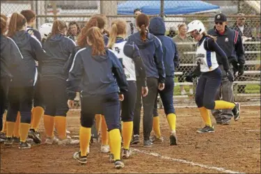  ?? JEN FORBUS — THE MORNING JOURNAL ?? Danielle Stevens, right is greeted by her fellow Bulldogs as she crosses the plate after a three-run home run against Wellington.