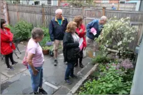  ?? LAUREN HALLIGAN - MEDIANEWS GROUP ?? One attendee sniffs a particular­ly fragrant plant in late event founder Nina Pattison’s garden on the 2019 Troy Hidden Garden Tour.