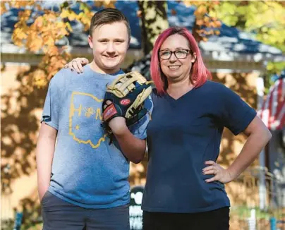  ?? AARON DOSTER/AP ?? Youth baseball player Liam Kennedy, left, and his mother, Rachel, stand Oct. 28 in front of their home in Monroe, Ohio.