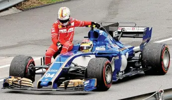  ??  ?? Coming to the rescue: Vettel’s miserable day is complete as he climbs out of his smashed-up Ferrari before riding home on the side of Pascal Wehrlein’s Sauber