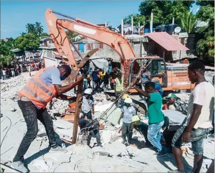  ??  ?? ANGUSTIA. Equipos de rescate buscan sobrevivie­ntes entre los escombros de una casa destruida en Les Cayes, golpeado por el sismo.
