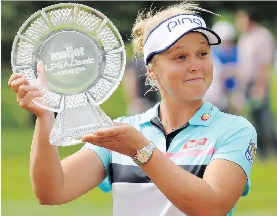  ?? CORY OLSEN/ASSOCIATED PRESS ?? Brooke Henderson with the winner's trophy after winning the Meijer LPGA Classic by two strokes Sunday at Blythefiel­d Country Club in Grand Rapids, Mich.