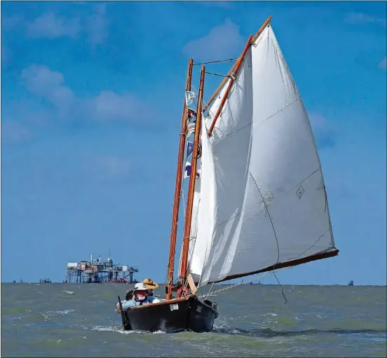  ?? PAM LEBLANC/AMERICAN-STATESMAN PHOTOS ?? The Elsie B, a folding schooner built by Chris Breaux, sails past an oil rig during the five-day Texas 200 sailing event in June.