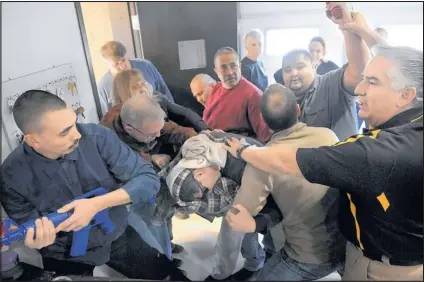  ?? PAT VASQUEZ-CUNNINGHAM/JOURNAL ?? Global One CEO Gilbert Baca Jr., right, helps train Gardner Zemke employees how to immobilize and disarm a gunman during an “active shooter” training exercise last week. At left, Jesus Dominguez takes hold of the shooter’s weapon, a replica...