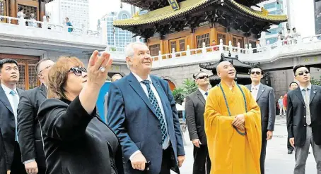  ?? Před dvěma lety navštívil prezident Miloš Zeman s chotí buddhistic­ký chrám Ťing-an v Šanghaji, kam se Číňané chodí modlit za finanční úspěch. Slibovaný příliv čínských investic do Česka ovšem zatím příliš úspěšný není. FOTO ČTK ?? Modlitba za úspěch.