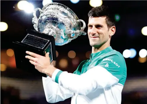  ?? Associated Press ?? ↑
Novak Djokovic holds the trophy after winning the Australian Open on Sunday.