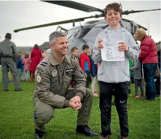  ?? PHOTO: SUPPLIED/NZ DEFENCE FORCE ?? Air component commander Air Commodore Darryn Webb and Alex Bowmar, 10, with the letter he wrote requesting that one of the air force’s helicopter­s visit his school.