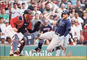 ?? Winslow Townson / Associated Press ?? The Rays’ Austin Meadows, right, slides safely home with an inside-the-park home run as Red Sox catcher Christian Vazquez waits for the throw during the ninth inning on Monday in Boston.