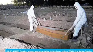  ?? — AFP ?? RIO DE JANEIRO: Cemetery workers wearing protective clothing bury a victim of COVID-19 at the Sao Franciso Xavier cemetery in Rio de Janeiro.