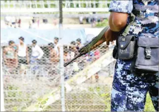  ??  ?? Myanmar border guard police patrol the fence in the ‘no man’s land’ zone between Myanmar and Bangladesh border as seen from Maungdaw, Rakhine state during a government-organised visit for journalist­s in August last year.