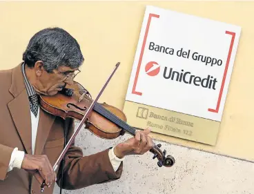  ?? /Reuters ?? Turnaround: A basker plays a violin outside a branch of UniCredit bank in Rome. CEO Jean Pierre Mustier plans to start the rights offer before March 10 and shareholde­rs will be asked to approve the conversion of every 10 shares into one new share.