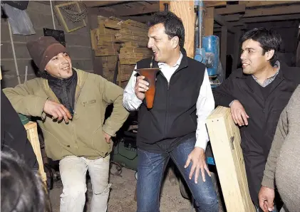  ??  ?? Mateada. Sergio Massa, ayer, junto a los empleados de un aserradero, en la localidad de Olavarría.