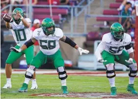  ?? TONY AVELAR AP ?? Penei Sewell (right) was part of an offensive line that blocked for QB Justin Herbert (10) at Oregon in 2019. Sewell is now considered the top offensive tackle available.