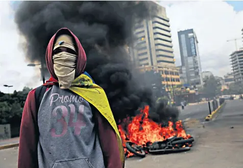  ??  ?? An opposition supporter in the streets of Caracas. More than 100 people have lost their lives since April 100 in violent protests against the rule of Nicolas Maduro