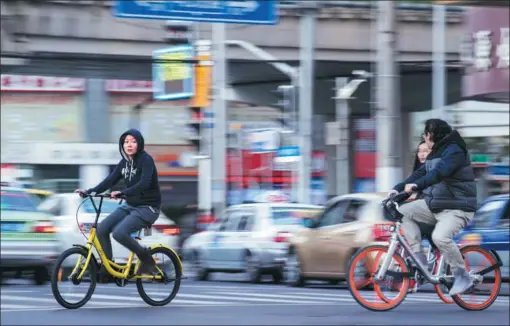  ?? PHOTOS BY JOHANNES EISELE / AGENCE FRANCE-PRESSE ?? People ride bicycles produced by Ofo (left) and Mobike sharing companies on the streets of Shanghai.