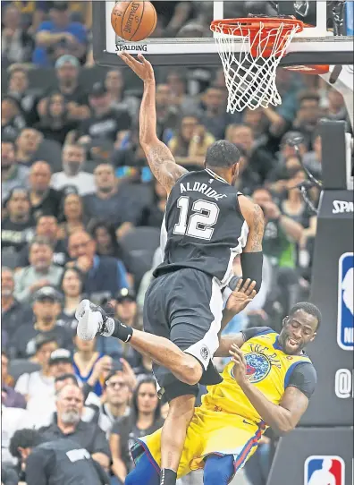  ?? RONALD CORTES — THE ASSOCIATED PRESS ?? Warriors forward Draymond Green takes a charge from San Antonio’s LaMarcus Aldridge during the first half of Monday’s loss.