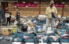  ?? Foto: ČTK ?? Evakuace. Žena třídí oblečení v útulku pro evakuované ve městě Angleur nedaleko belgického Lutychu. Povodně, které zdevastova­ly Německo, tvrdě zasáhly i Belgii.