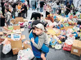  ?? OLGA MALTSEVA AFP VIA GETTY IMAGES ?? Evacuees from Russia’s Belgorod region, which borders Ukraine, receive aid Saturday in a shelter.