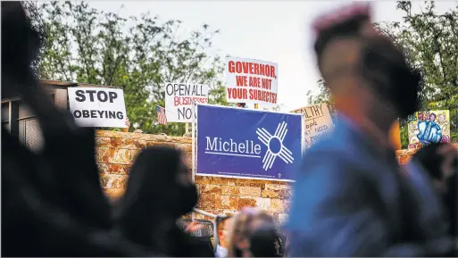  ?? GABRIELA CAMPOS/THE NEW MEXICAN ?? Protesters wave signs while shouting and chanting into megaphones Thursday during the presentati­ons at Gov. Michelle Lujan Grisham’s campaign event at the Albuquerqu­e Museum. Taking the stage, the governor immediatel­y made light of the situation. ‘I know it’s going to be loud, and I just have to say I’m sorry that we picked the same location that the QAnon lizard people meeting was at,’ she said, laughing.