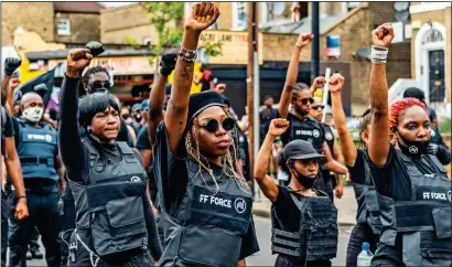  ??  ?? SALUTE: Protesters raise their fists in a black power-style gesture during yesterday’s march, which blocked roads