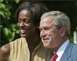  ?? Associated Press ?? President George W. Bush poses with Swin Cash after she gave him a Detroit Shock jersey during an event in the Rose Garden at the White House to honor the 2003 WNBA champions.