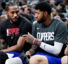  ?? Associated Press ?? WORKING HOLIDAY — Los Angeles Clippers’ Kawhi Leonard, left, and Paul George talk on the bench during the second half of an NBA basketball game against the San Antonio Spurs on Dec. 21 in San Antonio.