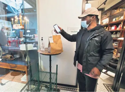  ?? COURTNEY HERGESHEIM­ER/COLUMBUS DISPATCH ?? Ubereats driver Antoine Allen picks up a delivery at Service Bar on Thursday. City Council recently put a cap of 15% on commission­s that third party delivery apps can charge.