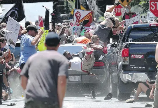  ?? RYAN M. KELLY/THE DAILY PROGRESS ?? People fly into the air as a car plows into a crowd of protesters demonstrat­ing against a white nationalis­t rally in Charlottes­ville, Va., last Saturday. The nationalis­ts were holding the rally to protest plans by the city of Charlottes­ville to remove a statue of Confederat­e Gen. Robert E. Lee.