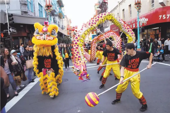  ?? Photos by Paul Chinn / The Chronicle ?? A lion and a dragon perform in a parade at the Chinese New Year Flower Market Fair, which kicks off events celebratin­g the Year of the Dog in San Francisco.
