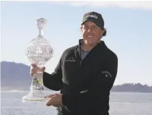  ?? Eric Risberg / Associated Press ?? Phil Mickelson finished his win Monday, joining Tiger Woods as the only golfers to exceed $90 million in career earnings.