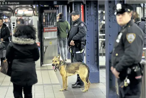  ?? SETH WENIG/THE ASSOCIATED PRESS ?? Police officers patrol in the passageway connecting New York City’s Port Authority bus terminal and the Times Square subway station, on Tuesday, near the site of Monday’s explosion.