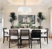  ??  ?? Building on a palette of neutral tones, designer Donna Correy adds drama to the dining room with an elaborate centrepiec­e and chandelier.